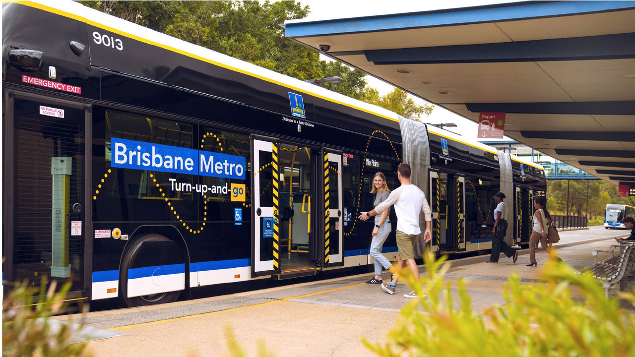 Two pairs of passengers at station boarding a metro through two different doors.