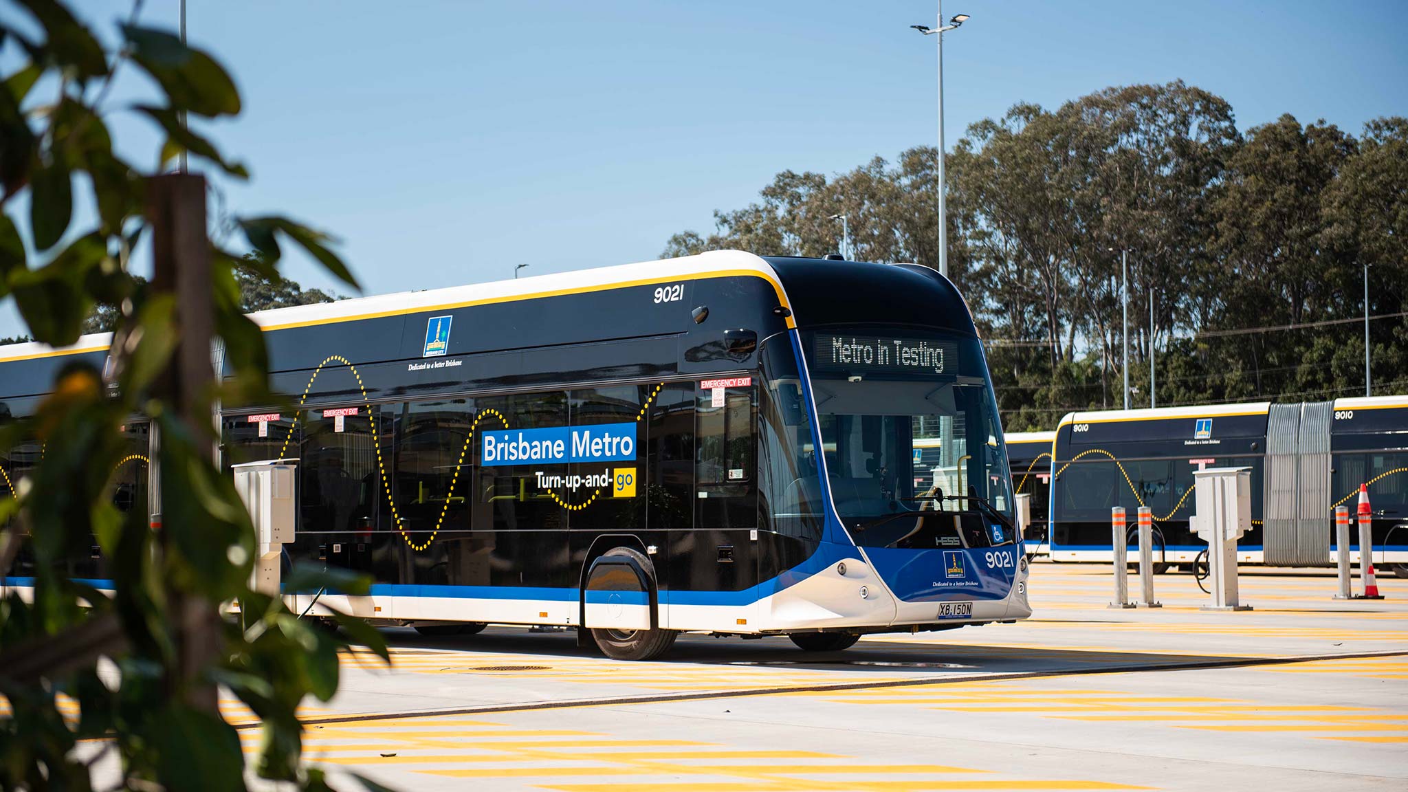 Artist impression of the 2-storey Brisbane Metro workshop with metro vehicles inside and entering the building.